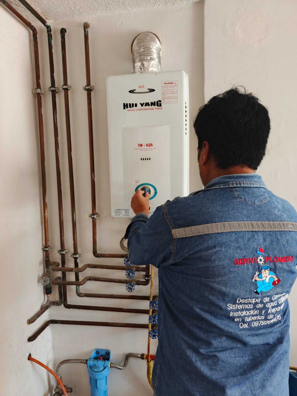 Técnico instalando calefón a gas con tuberías de cobre